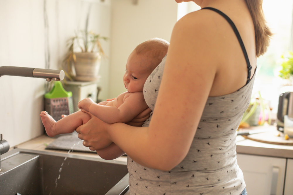 Windelfrei-Methode: Baby über das Waschbecken gehalten